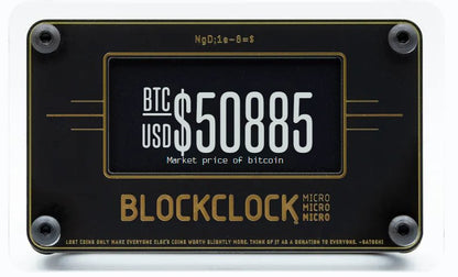 The Blockclock Micro by UTXO Dreams provides a real-time display of Bitcoin information, showcasing the current market price. The screen displays "BTC USD $50885" in gray and white text on a black background. Its sleek, rectangular design features four corner screws and a subtle decorative border.